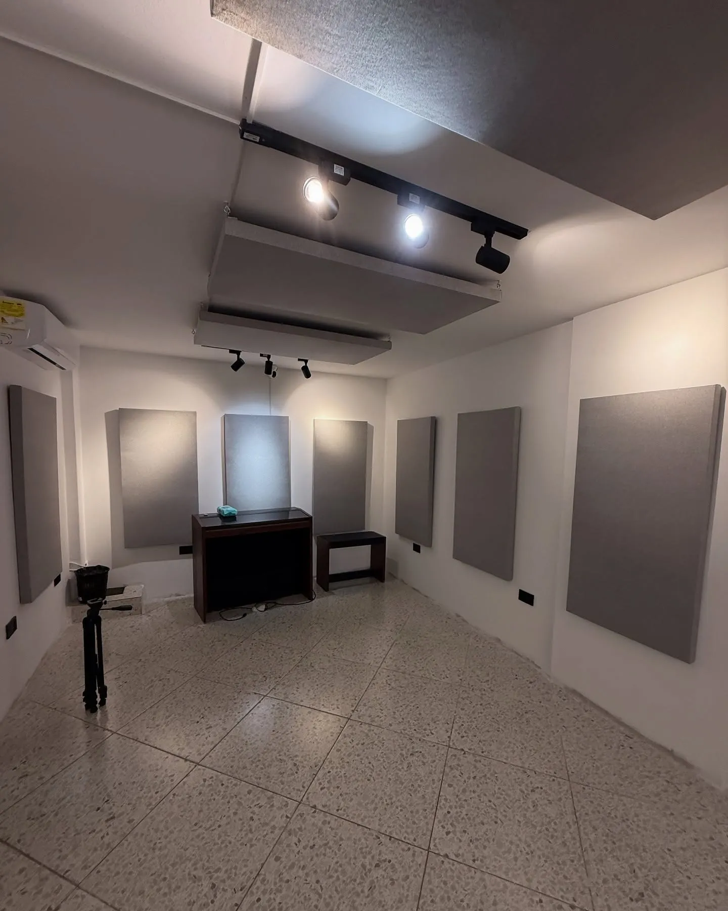 Sala blanca con paneles grises en las paredes y nubes en el techo